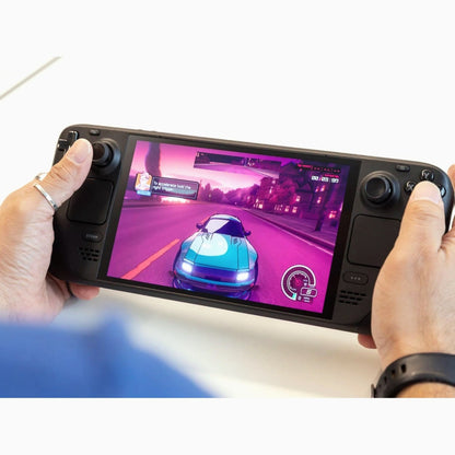 Person holding a Steam Deck OLED in both hands while playing a fast‑paced action game.