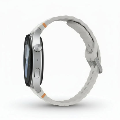 Top‑down shot of Galaxy Watch7 44mm Silver on a white surface with sport band laid flat.